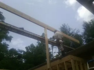 Carpenter setting a ridge beam over a new addition frame — Ice Dam Removal by Roofing Brothers in North Webster