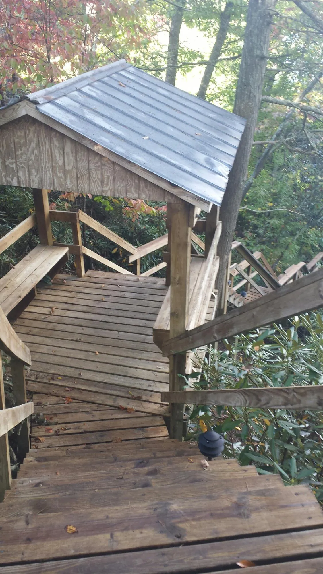 Metal roofed shelter over wooden steps on a wooded walkway — Skylight Repair & Installation work by our crew in North Webster